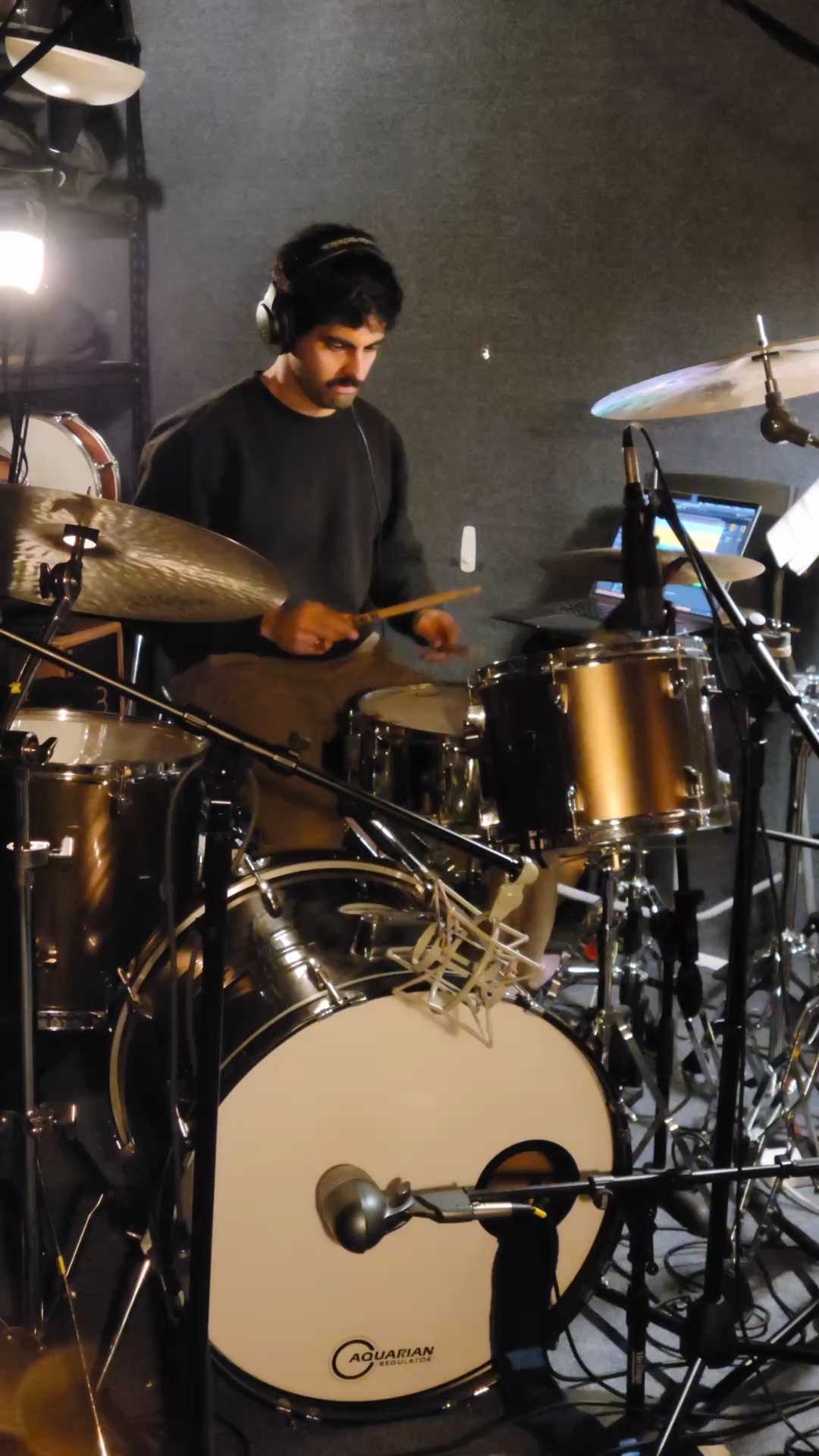 Drummer tracking in the studio with headphones on