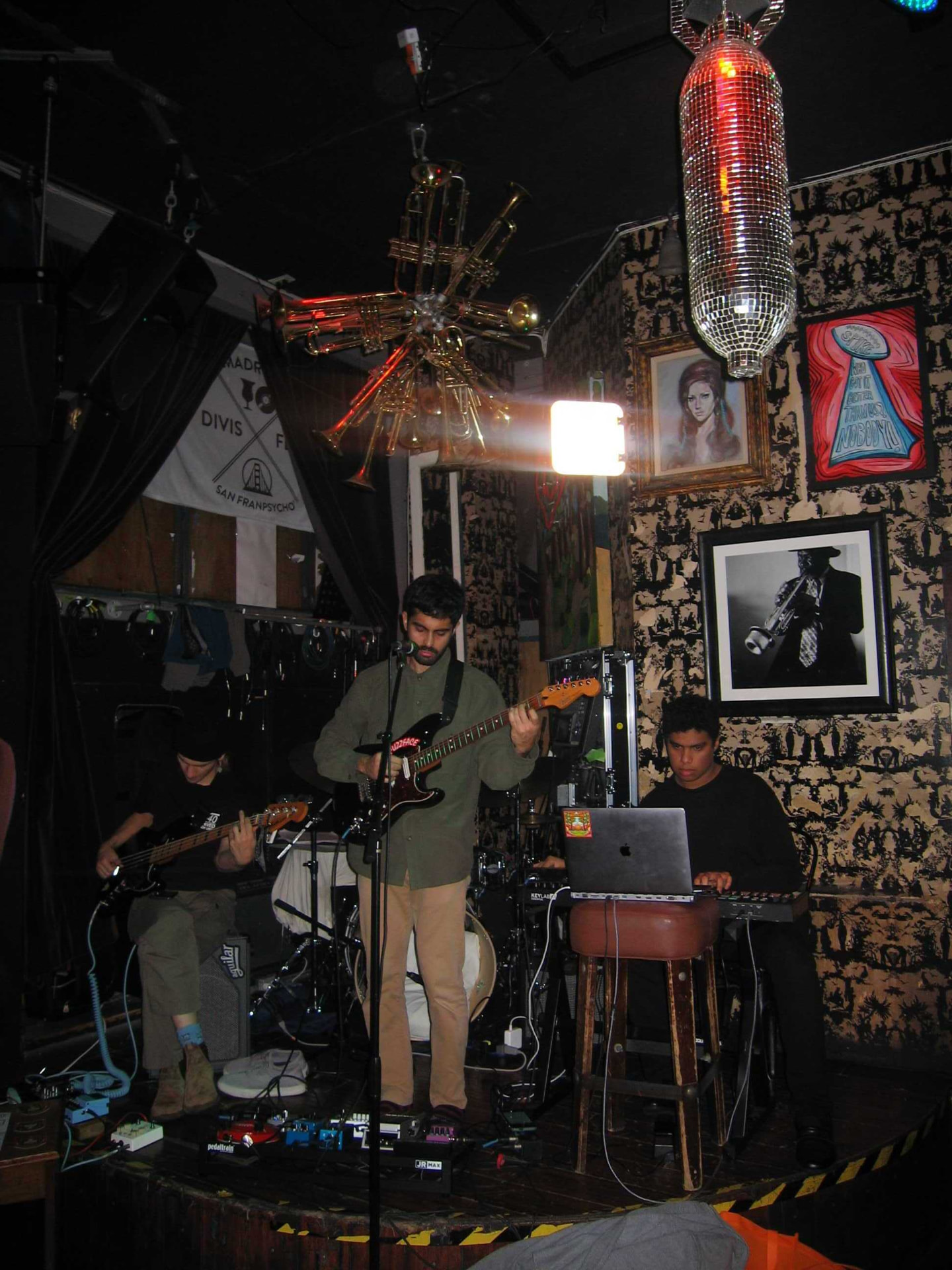 Full band playing a small club stage with a disco ball